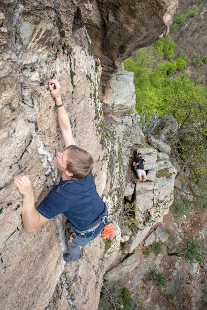 istock High angle view of young man climbing vertical rock face 1397897899