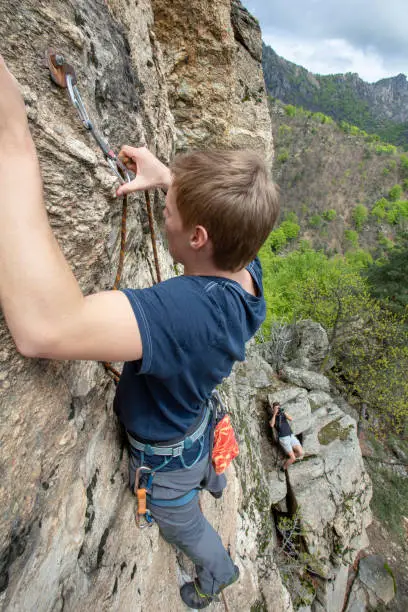 Photo of High angle view of young man climbing vertical rock face