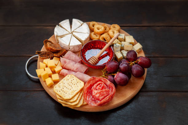 istock Appetizers board with assorted cheese, meat, sausage rosette, grape and salty cookies 1397898331
