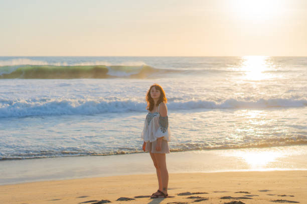 istock Woman walking on the beach at sunset 1397899416