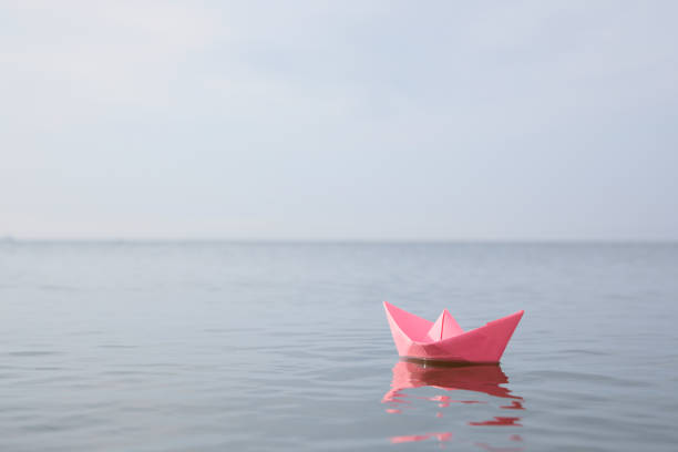 istock Pink paper boat on water surface, space for text 1397902111