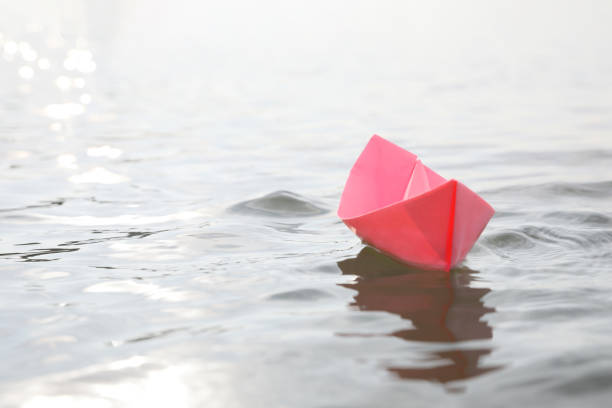 istock Pink paper boat on water surface, space for text 1397902136
