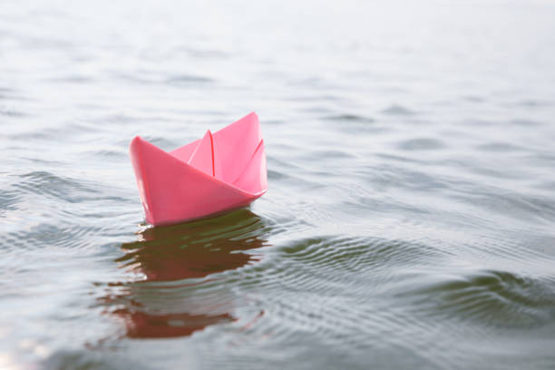 istock Pink paper boat on water surface, space for text 1397902199