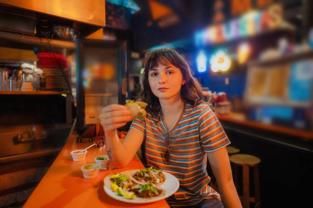 istock Woman eating taco in a bar 1397902506