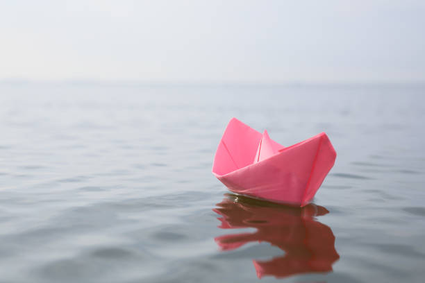 istock Pink paper boat on water surface, space for text 1397902513