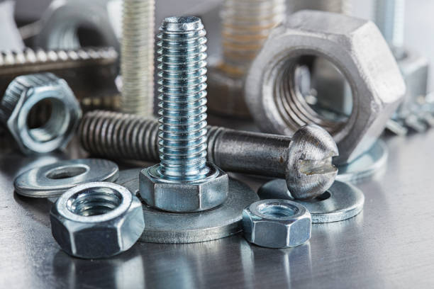 set of different nuts, bolts, screws, washers and drill bits,thread tap and mill cutters on steel plate background. Locksmithing deal.