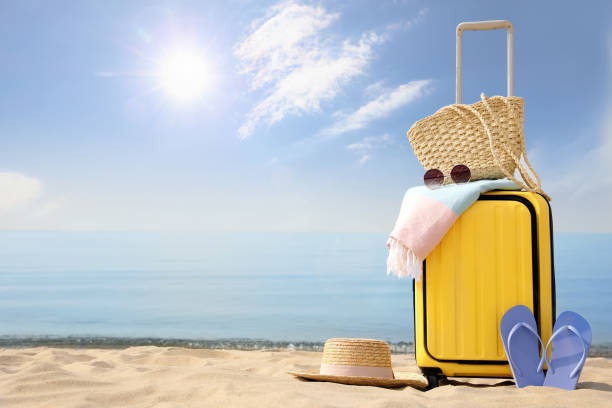 istock Yellow suitcase with beach items on sandy seashore, space for text 1397903013