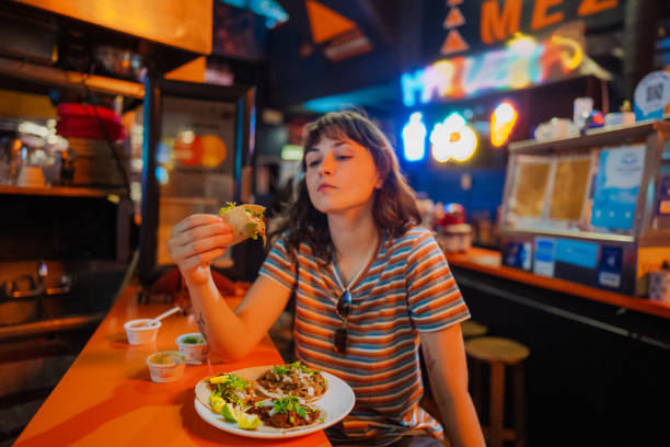 istock Woman eating taco in a bar 1397903338