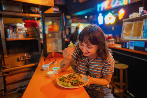 istock Woman eating taco in a bar 1397903642