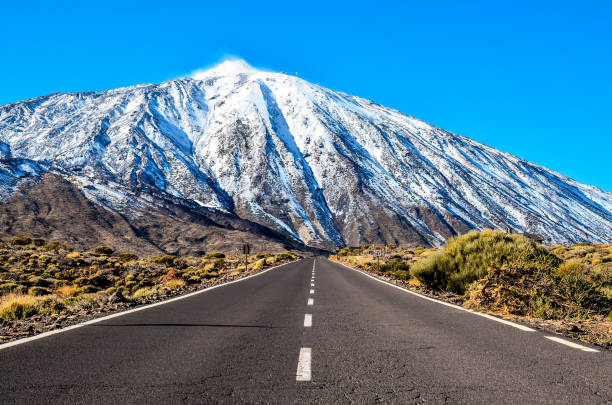 felsformation roque cinchado, teil von roques de garcia, im teide nationalpark, teneriffa, kanarische inseln, spanien. schneebedeckter pico del teide im hintergrund. - pico de teide stock-fotos und bilder