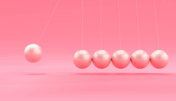 istock pink newton cradle in motion. 1397906761