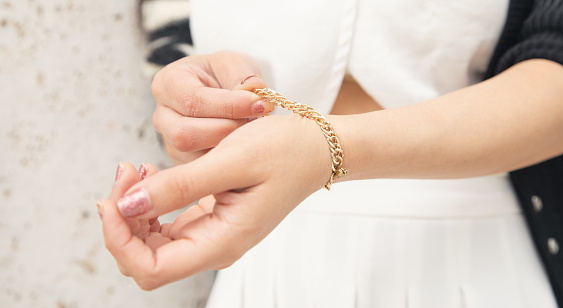 A close up of a woman’s hand with wedding and engagement rings on finger