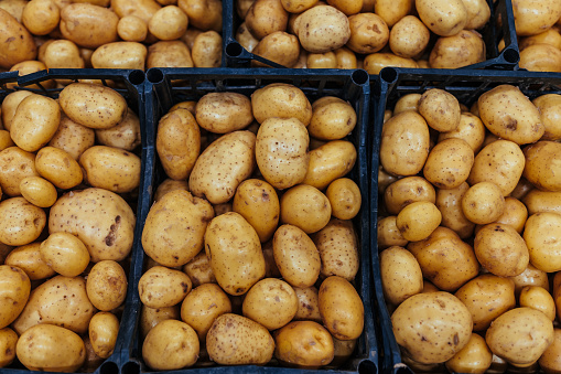 A large number of potatoes in plastic creates prepared for sales