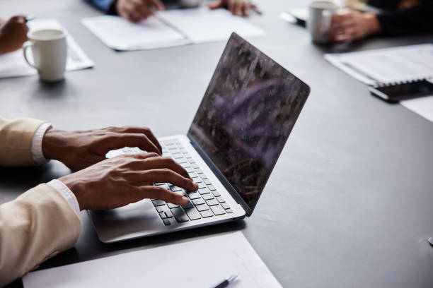 istock Young businessman working on a laptop during a meeting around an office table 1397914350