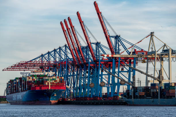 Port of Hamburg Container Terminal. The image shows several container cranes loading container ships. The image was captured during spring season.