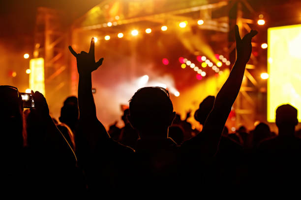 istock Men and women with raised hands at a concert event. 1397914910