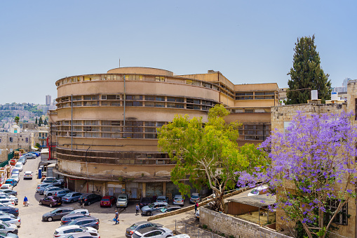 Haifa, Israel - May 13, 2022: View of the exterior of the historic Talpiot market building (1940, Bauhaus style), with visitors, in Hadar HaCarmel Neighborhood, Haifa, Israel