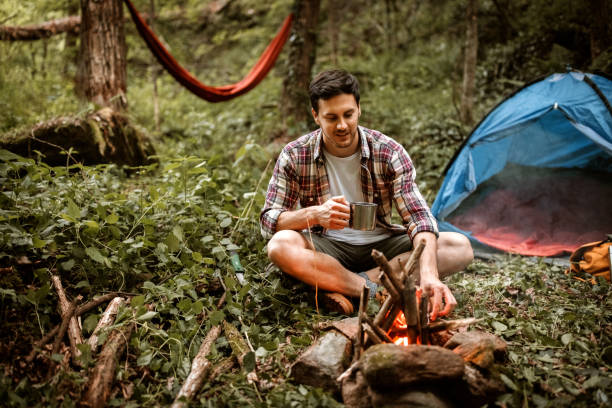 istock Young casually clothed hiker drinking tea near the campfire 1397916439