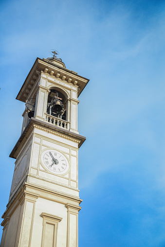 Church clock tower with bells in italian small city. High quality photo