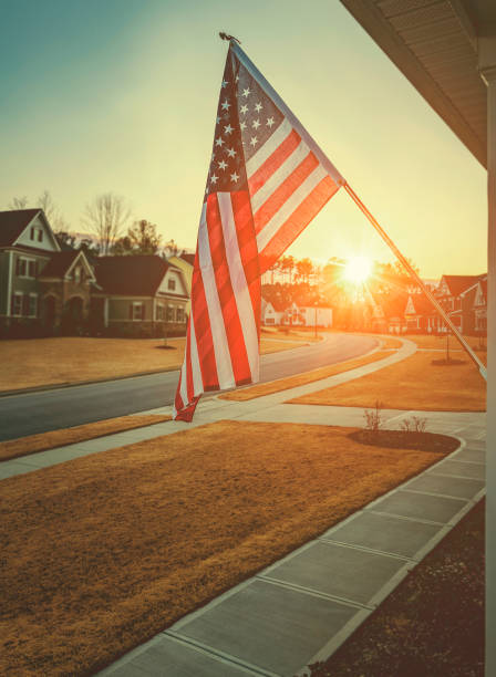 amerikanische flagge vor wohnhaus im morgengrauen - house dawn sunset usa stock-fotos und bilder