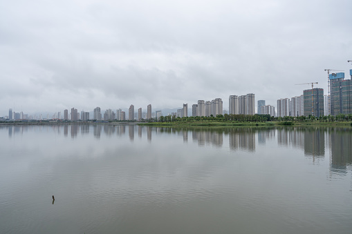 Lake and city skyline in fog after rain