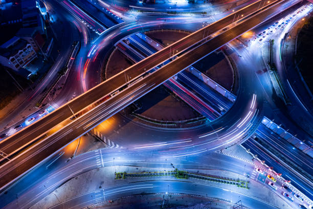 hyperlapse time-lapse del trasporto del traffico automobilistico expressway sopra la strada di intersezione nella notte della città di bangkok, vista aerea paesaggio urbano di innovazione avanzata - crisscross foto e immagini stock