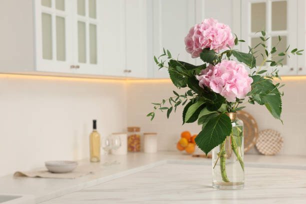 istock Beautiful pink hortensia flowers in vase on kitchen table. Space for text 1397929498