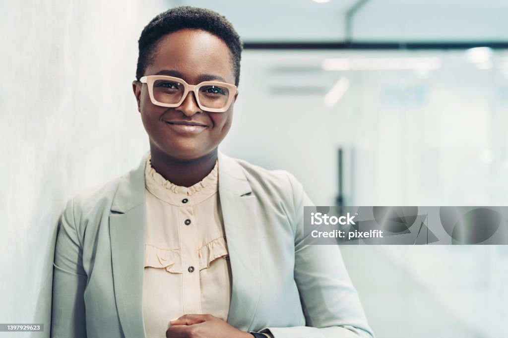 Portrait of a smiling young businesswoman standing in the corridor Smiling black businesswoman standing in the office Office Stock Photo