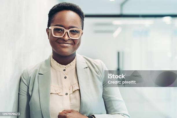 Portrait Of A Smiling Young Businesswoman Standing In The Corridor Stock Photo - Download Image Now