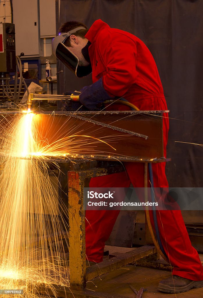 Schweißer in Rot Latzhose Schneiden Metall. - Lizenzfrei Arbeiten Stock-Foto