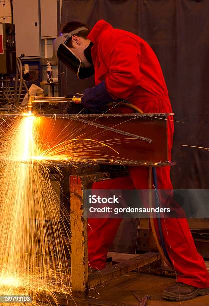 Schweißer In Rot Latzhose Schneiden Metall Stockfoto und mehr Bilder von Arbeiten - Arbeiten, Arbeiter, Bauarbeiter