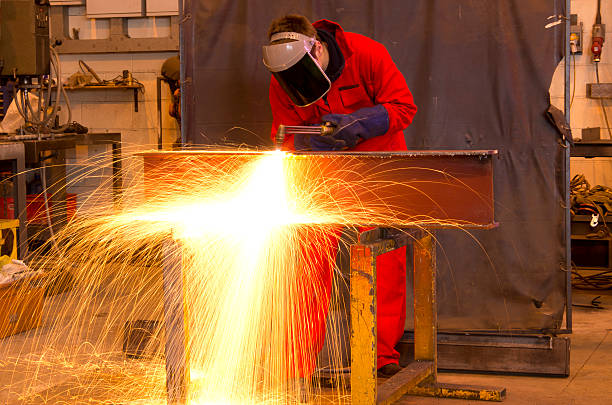 istock Welder bends to cut metal beam. 139793105