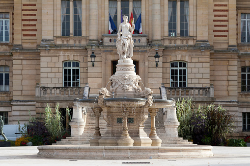 Evreux, France - October 18 2021: The monumental fountain of Évreux or fountain of the town hall, is a fountain dating from 1882, decorated with a marble group sculpted by Louis-Émile Décorchemont, located on the Place du General de Gaulle, in front of the Hôtel de city of Evreux.