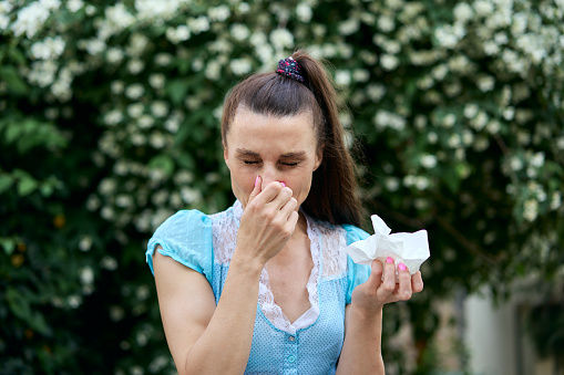 Attractive  woman coughing and sneezing outdoors. Sick people allergy or virus influenza concept.