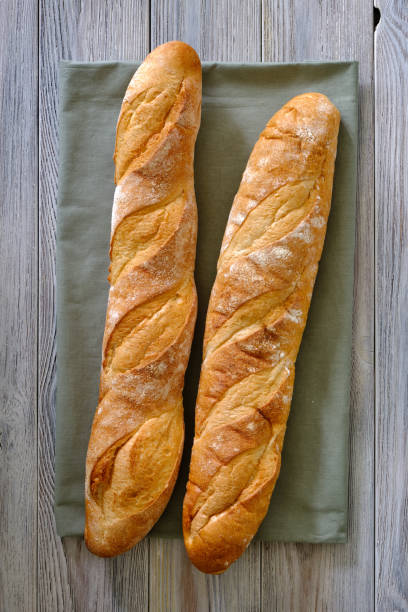 istock Fresh baguette with crispy crust on a wooden board close -up 1397932580