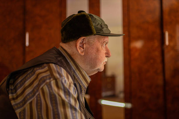 Depressed senior man sitting on bed and thinking.