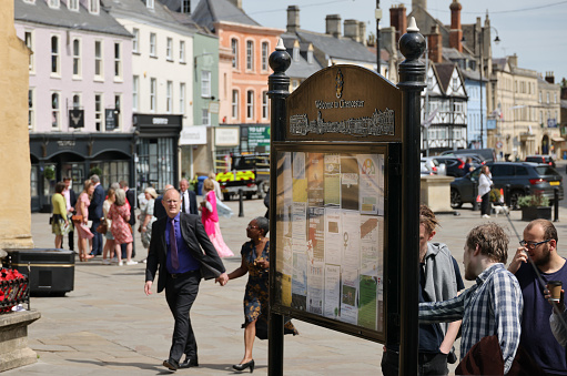 'Welcome to Cirencester' information sign greets tourists as they explore the quaint small streets and historical market place of the English Cotswold market town of Cirencester in Gloucestershire.