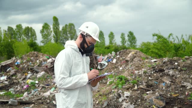 Garbage dump inspector records pollution level on city dump. Environmental pollution concept