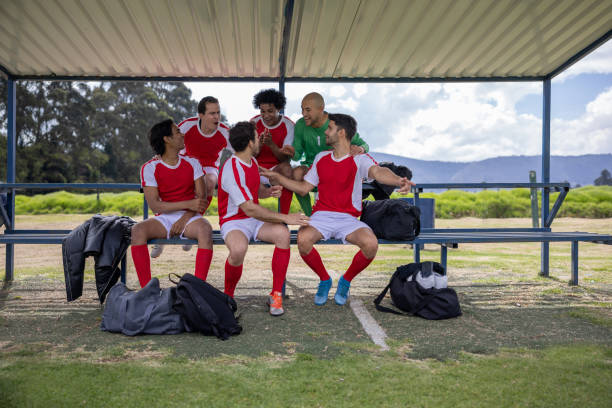 Happy football team talking on the bench before the game