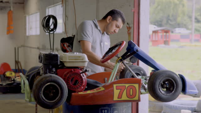 Latin American mechanic checking the level of air of in the tires of a go-cart