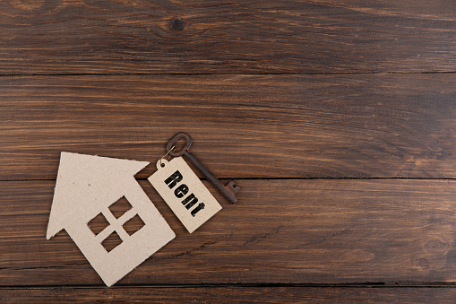 Real estate Rent concept - old key with tag and cardboard house