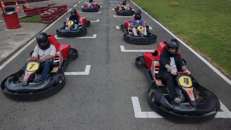 Group of friends at a go-cart racing track accelerating at the starting point