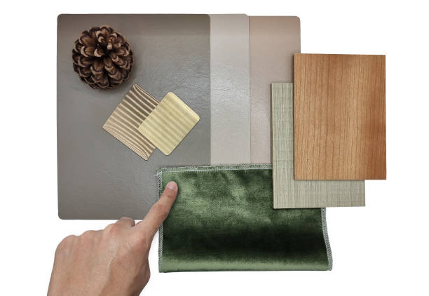 istock architect's hand choosing interior material including gold stainless, wooden veneer, green fabric, leather laminated samples isolated on background with clipping path including pine cone decorated. 1397947933