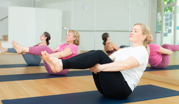 istock People relaxing and enjoying yoga elements - boat pose 1397949040
