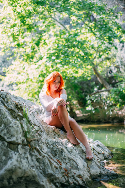 Young beautiful red haired woman looking into the camera. Natural happiness, joy and harmony