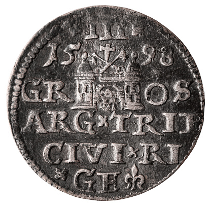 Single old silver coin 16th century isolated on white background. Reverse of three groschen with Greater coat of arms of Riga. 1598 year. Closeup