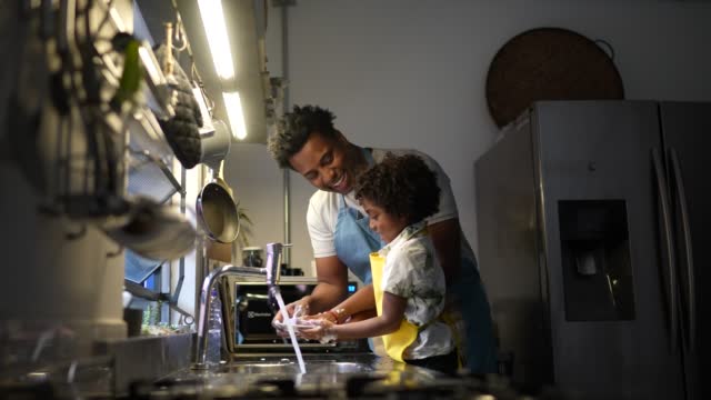 Father and son washing dishes at home