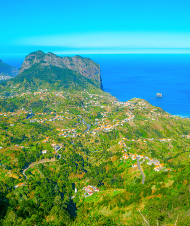 Landscape with Maderia village, mountains and ocean in a bright sunny day. Madeira island, Portugal