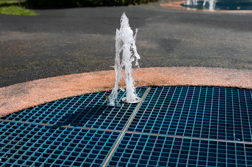 Water splashing from the fountain. Pure water flows under pressure from the tube. City fountain in the summer in the city.