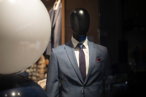Mannequin man in suit. Expensive suit on a black mannequin. Shop window.